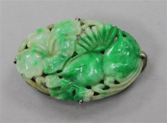 A 19ct century carved jadeite plaque, in later Chinese white metal brooch mount, 36mm.